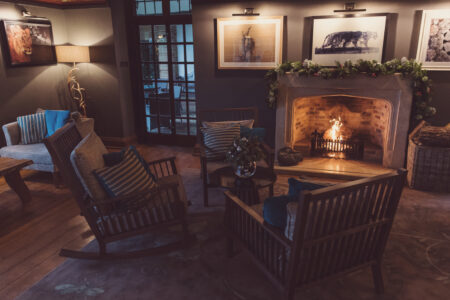 An image of a warm fireside seating area with chairs