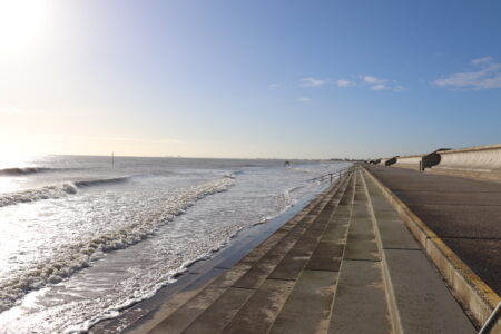 A concrete sea wall, promenade and steps lead into the sea