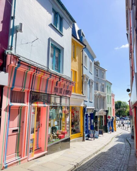 A row of colourful shops in a narrow cobbled street