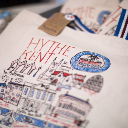 A canvas bag covered in red, black and blue drawings and words the largest of which say' Hythe Kent'